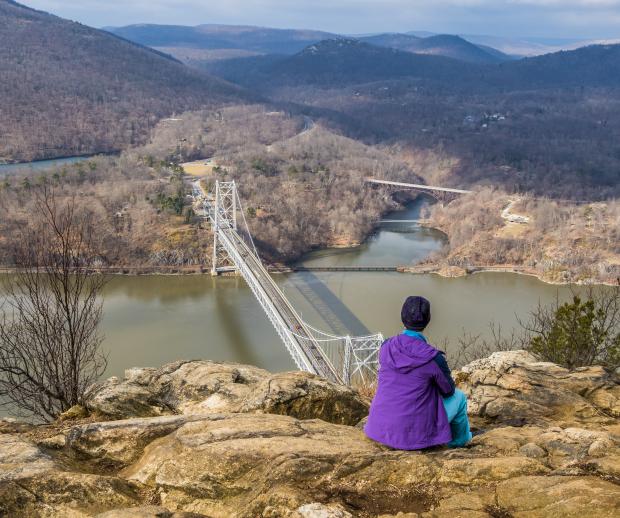 Hiker on Anthony's Nose overlooking Bear Mountain. Credit: Adobe Stock